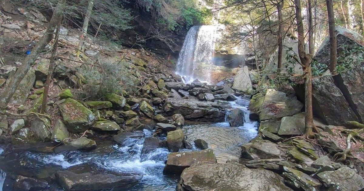 Waterfall flowing over rocks in a forest setting.
