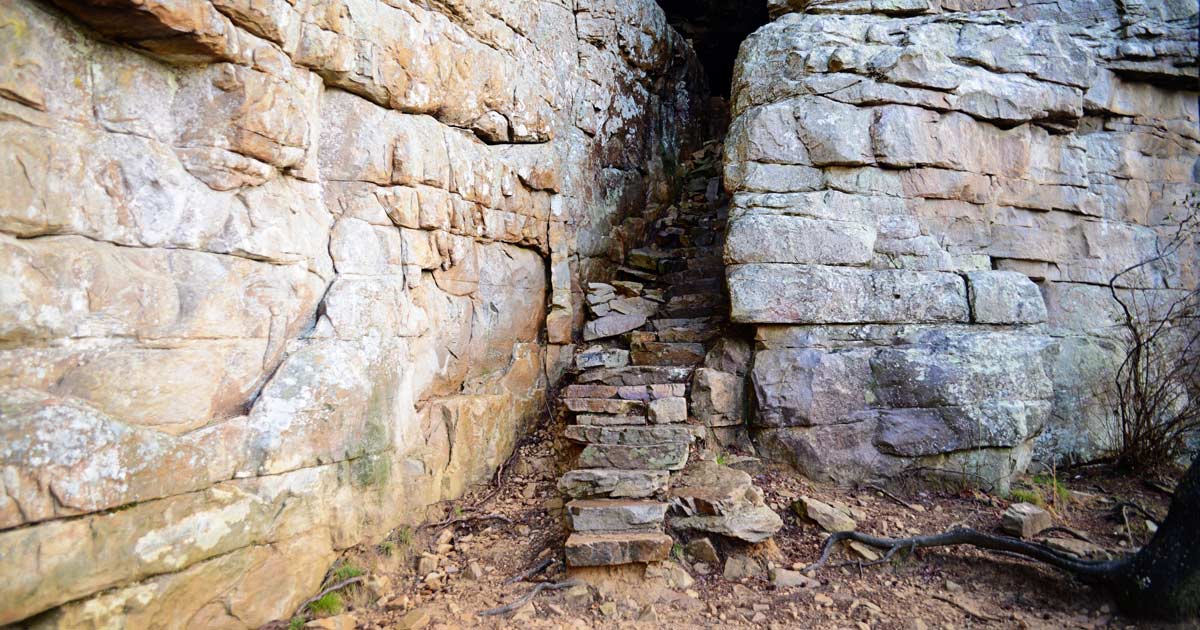 Rocky stairs leading into a narrow stone passage.