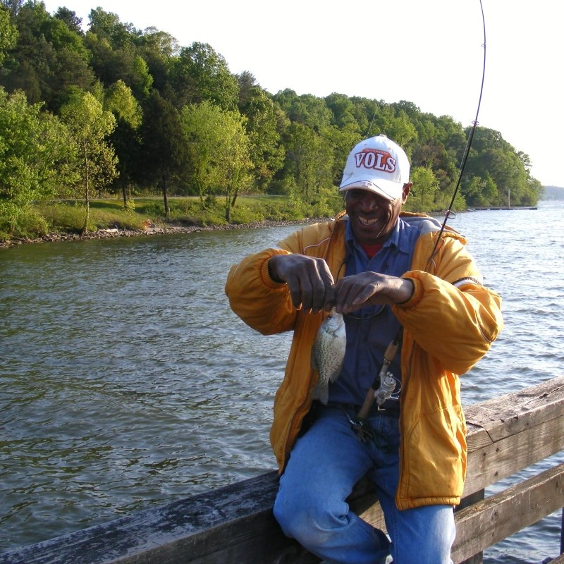 A person fishing along the shore at Booker T. Washington State Park.