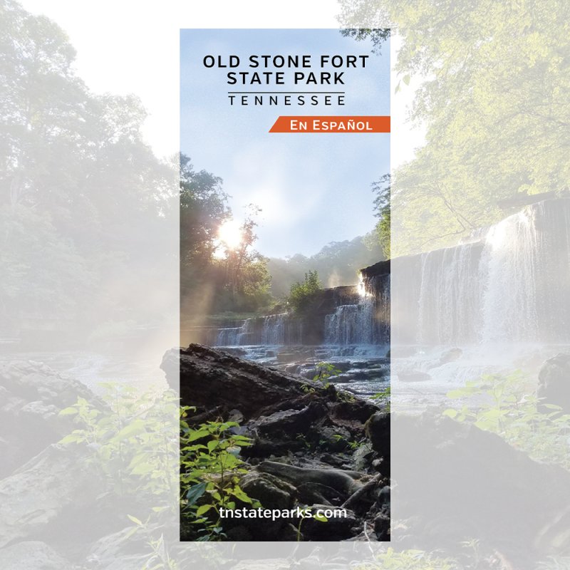 Scenic view of a waterfall at Old Stone Fort State Park, Tennessee. Sunlight filters through trees, casting a serene and natural ambiance. Text reads "En Español."