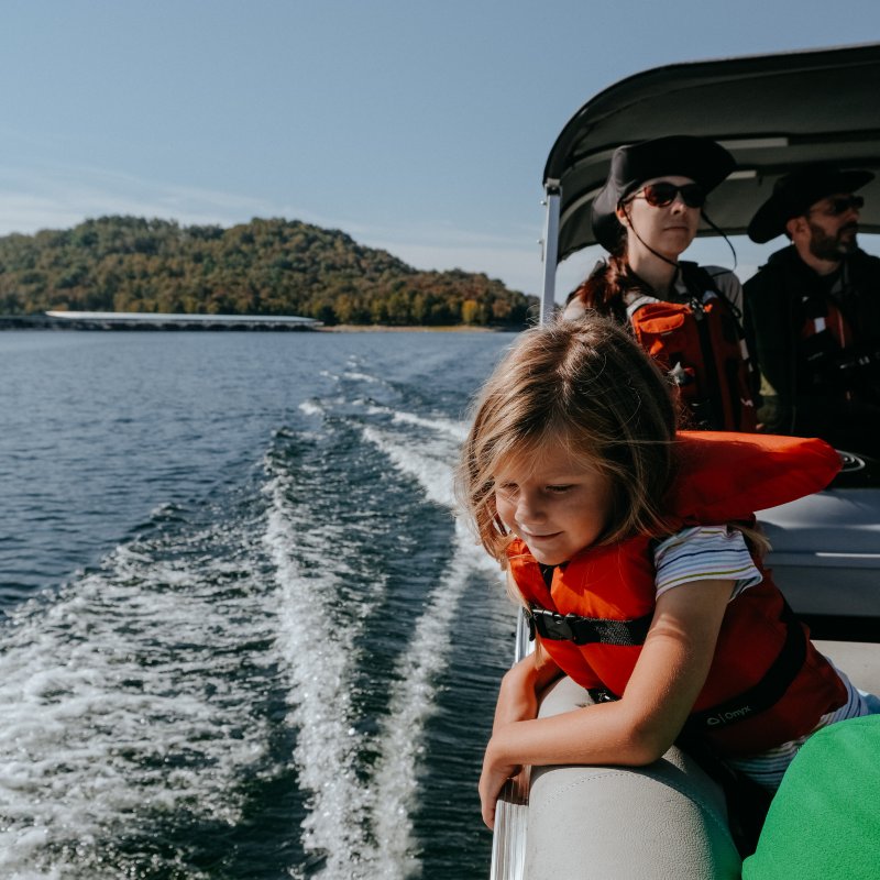 family on a boat with life jacket on