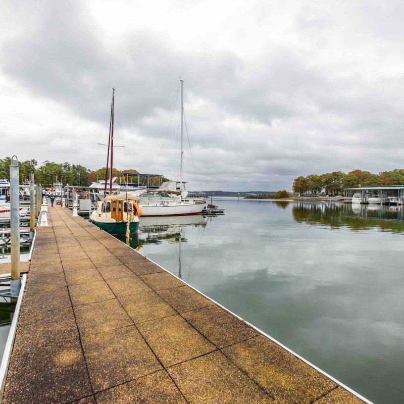view of marina landing dock with several boats parked on a cloudy day