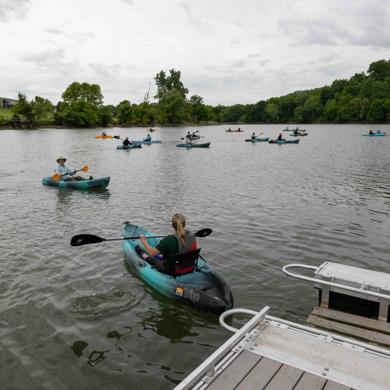 several people using accessibility canoes to paddle in a lake