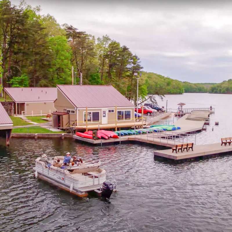 Aerial view of a lakeside with cabins and boats at docks.