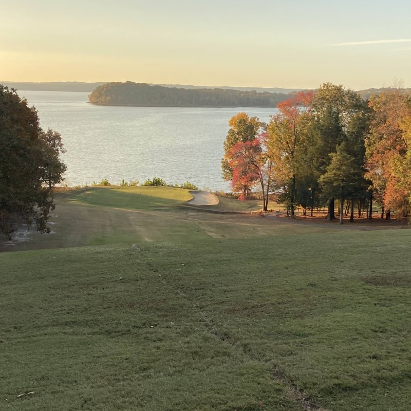 Autumn lakeside view with trees displaying fall colors.