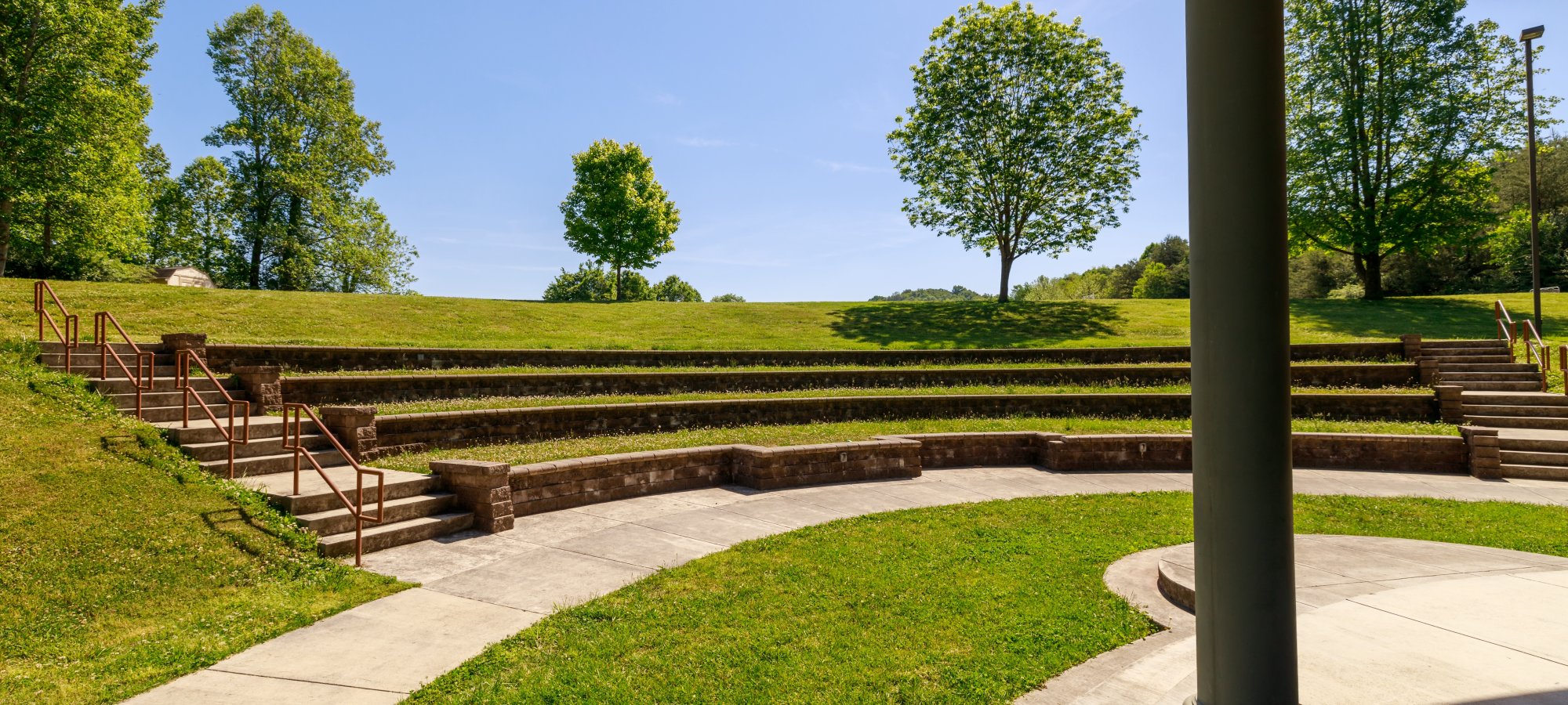 amphitheater with a stone stage that looks like a pavilion and stone seating area