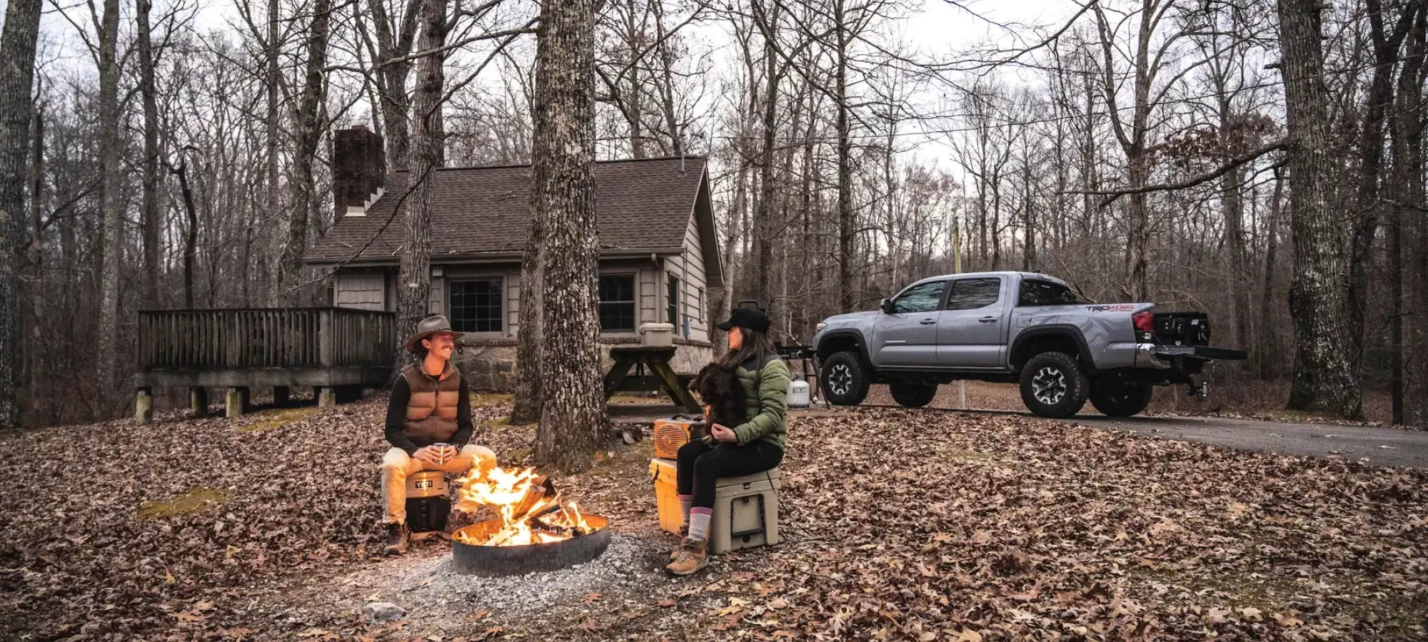 Rustic camping cabin at Natchez Trace with a porch and picnic table outside.