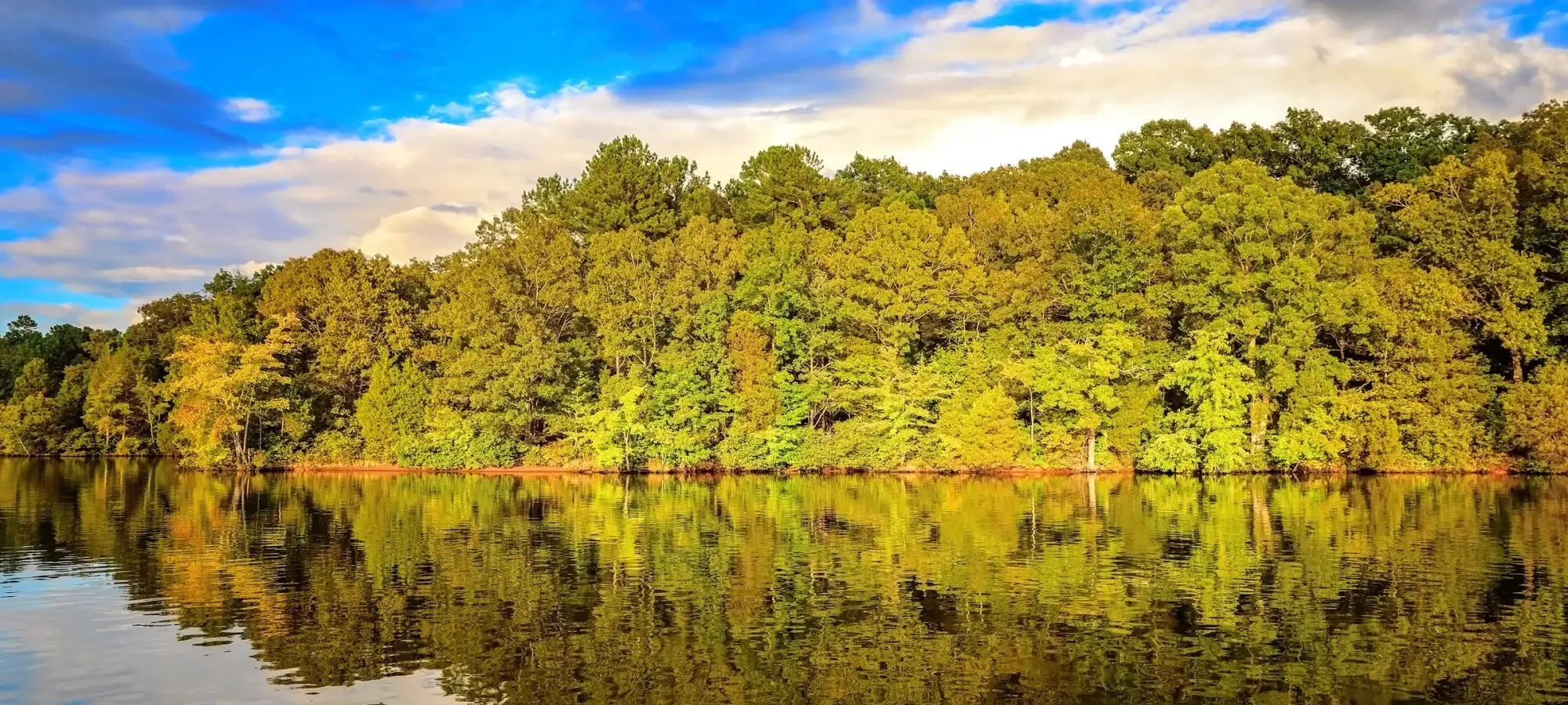 Third view of the lake showing a sandy shoreline.