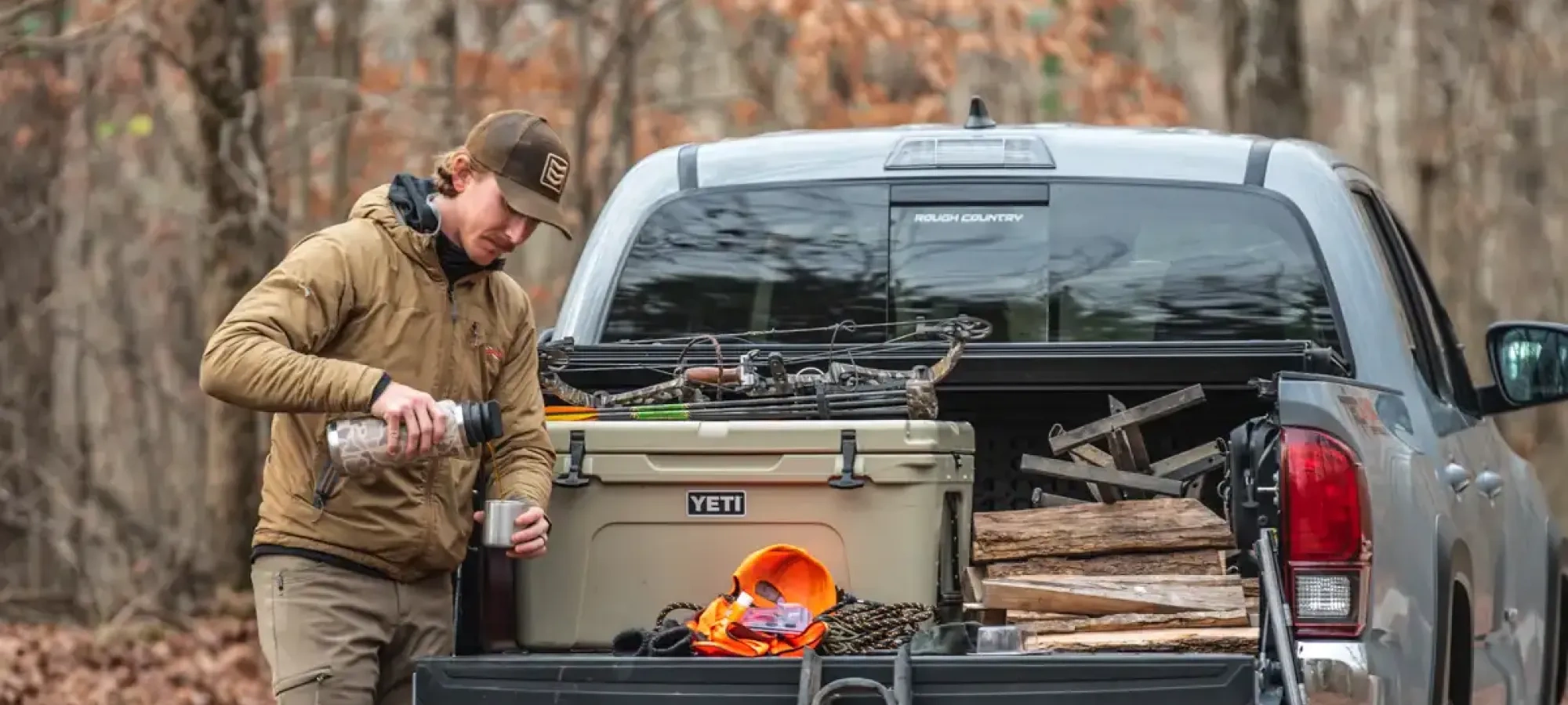 Truck camper parked in a wooded campsite.