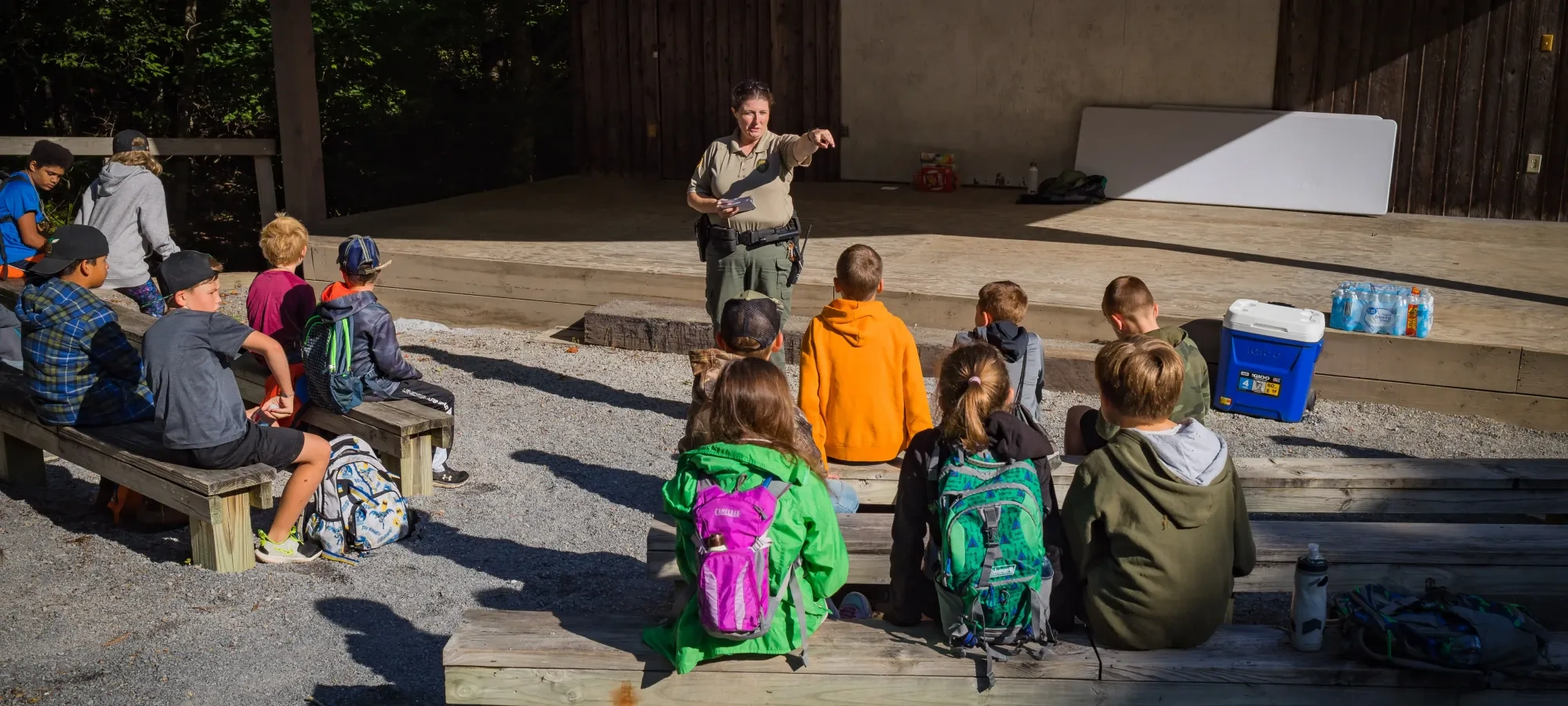 Park ranger speaking at a campfire program at the Roan Mountain amphitheater in the evening.