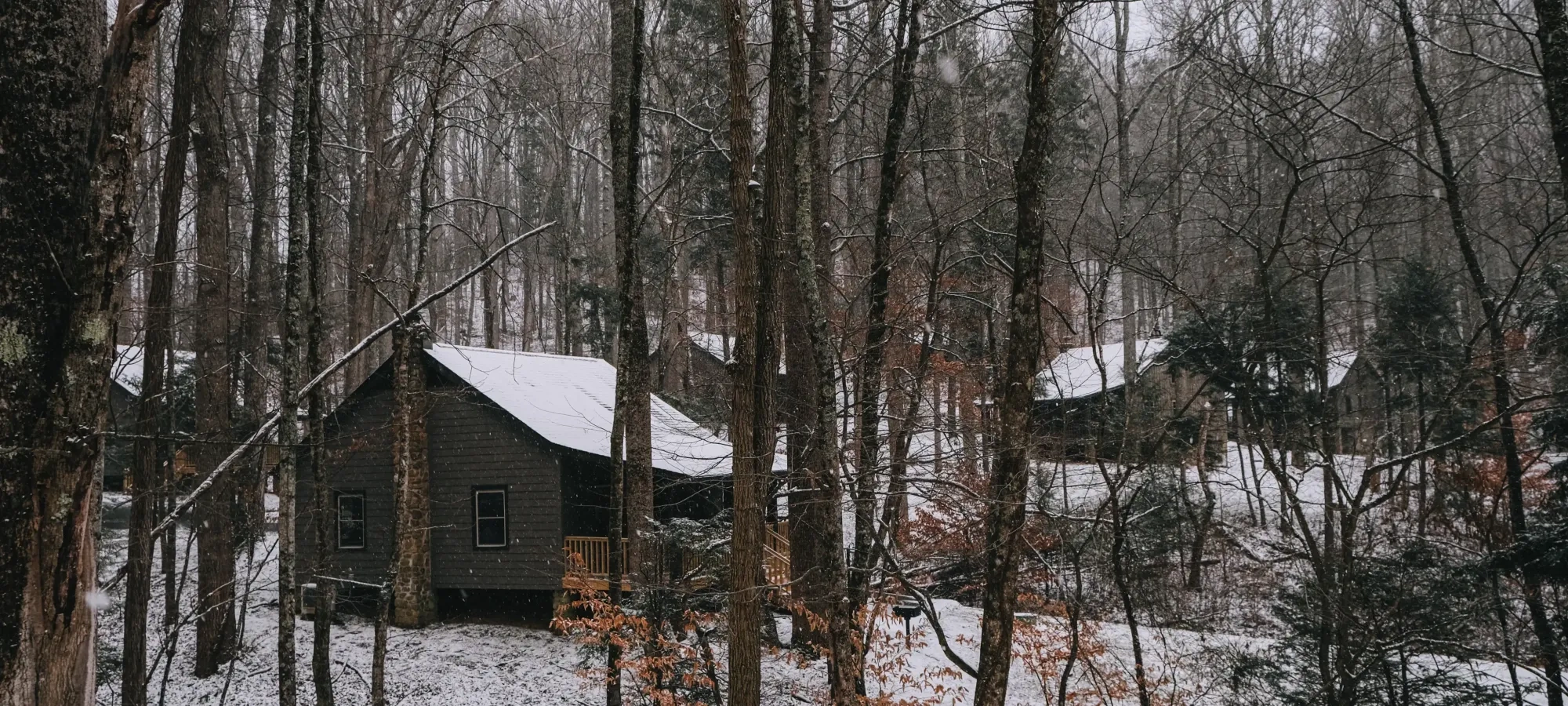 Small rustic cabins at Roan Mountain covered in snow. 