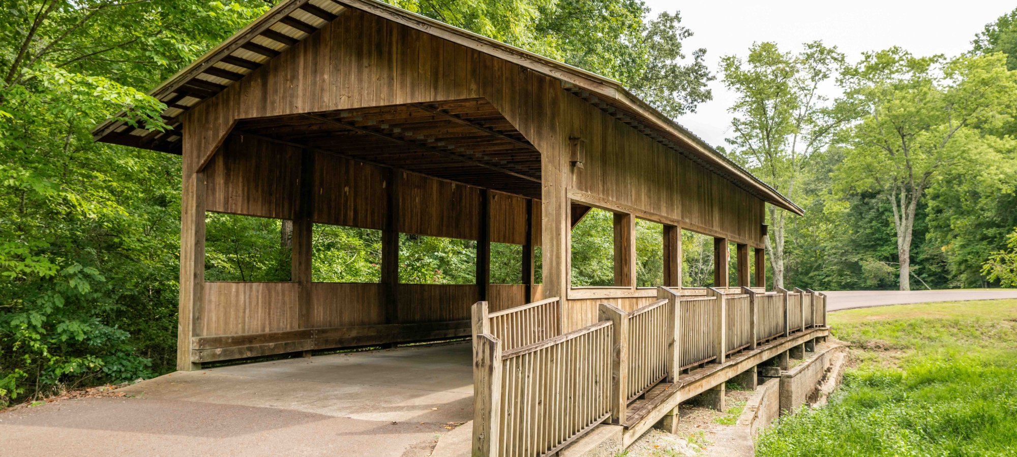 paved trail that leads to a covered bridge and then continues