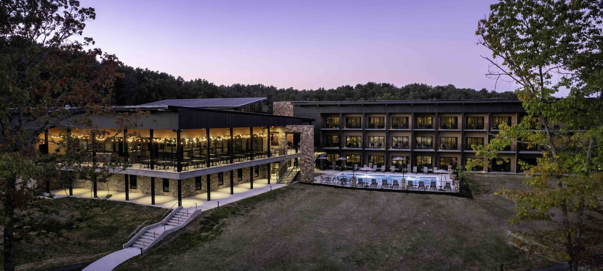 view of lodge outside at dusk with lights turned on