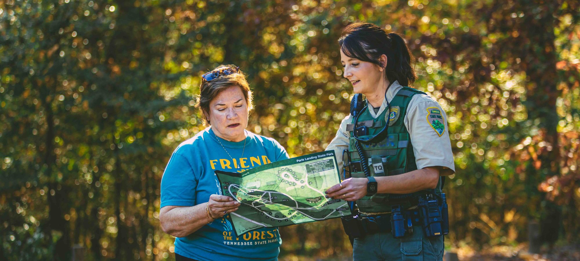 woman ranger helping woman with directions using a paper map