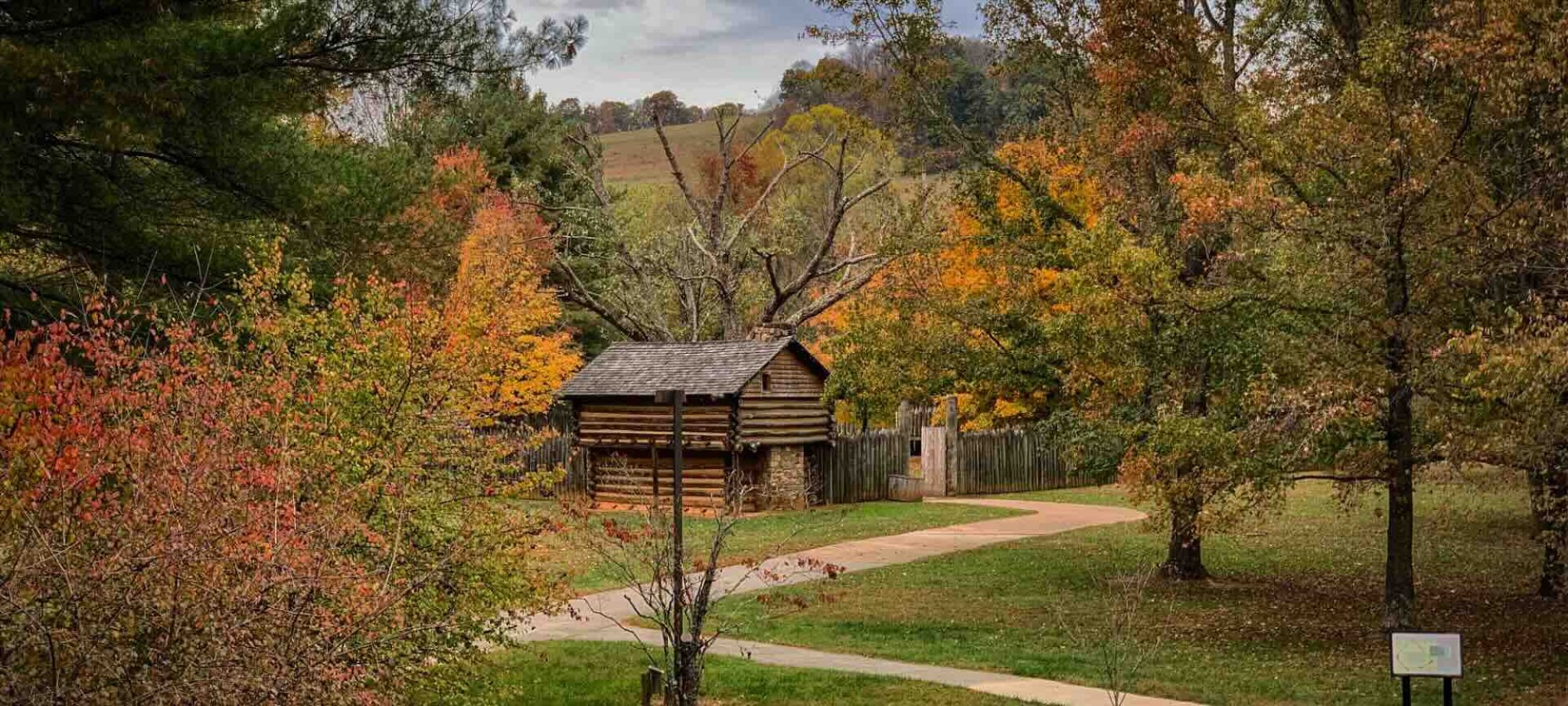 a wooden fort in the fall with paved trails leading to it