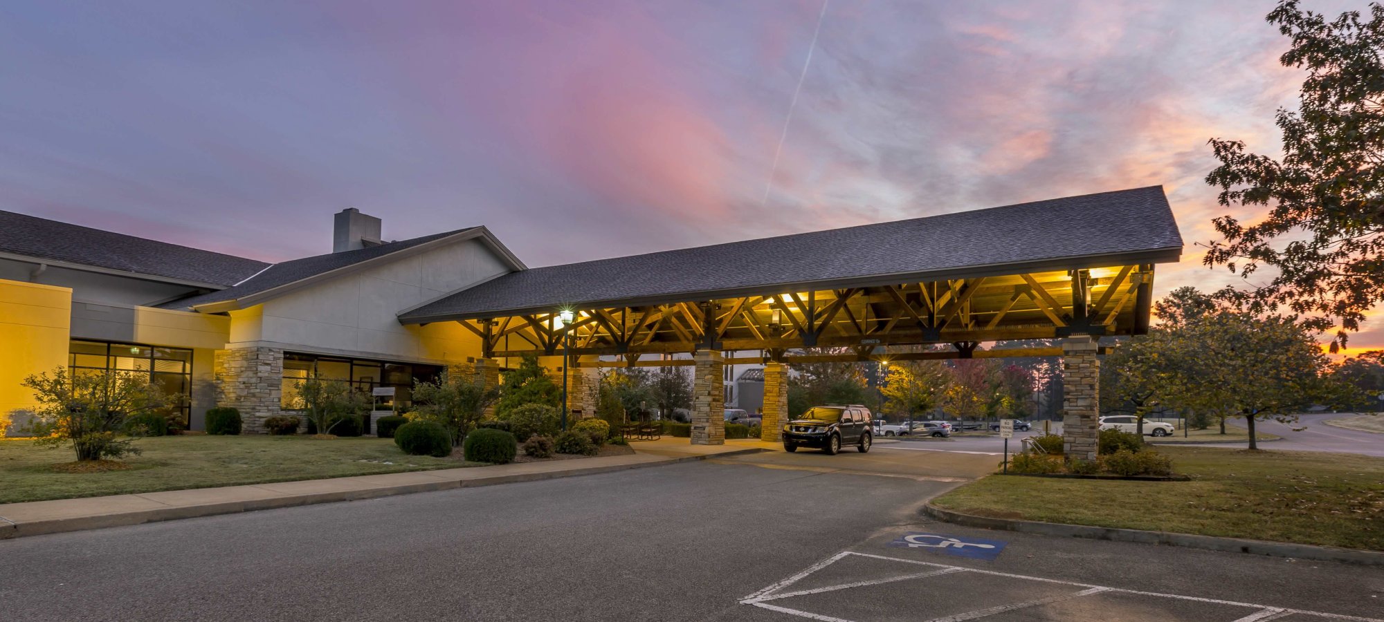 entrance of building with a large overhang and handicapped parking.