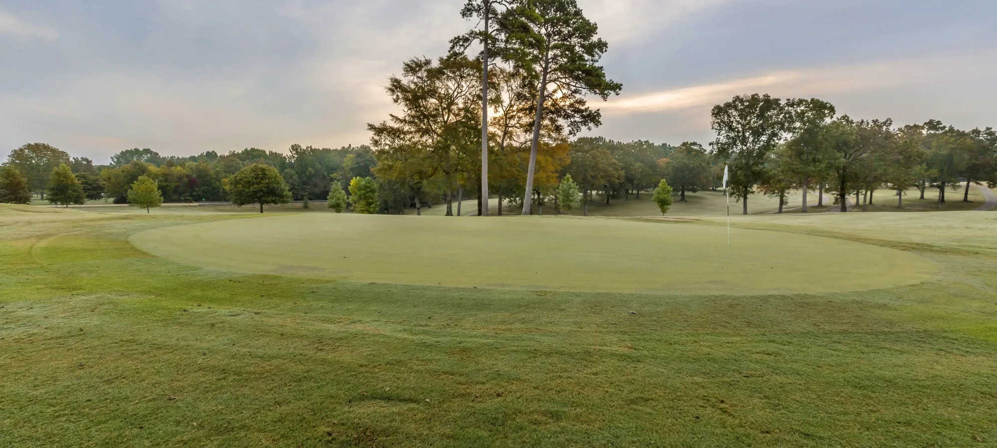 A hole on a golf course at sunset
