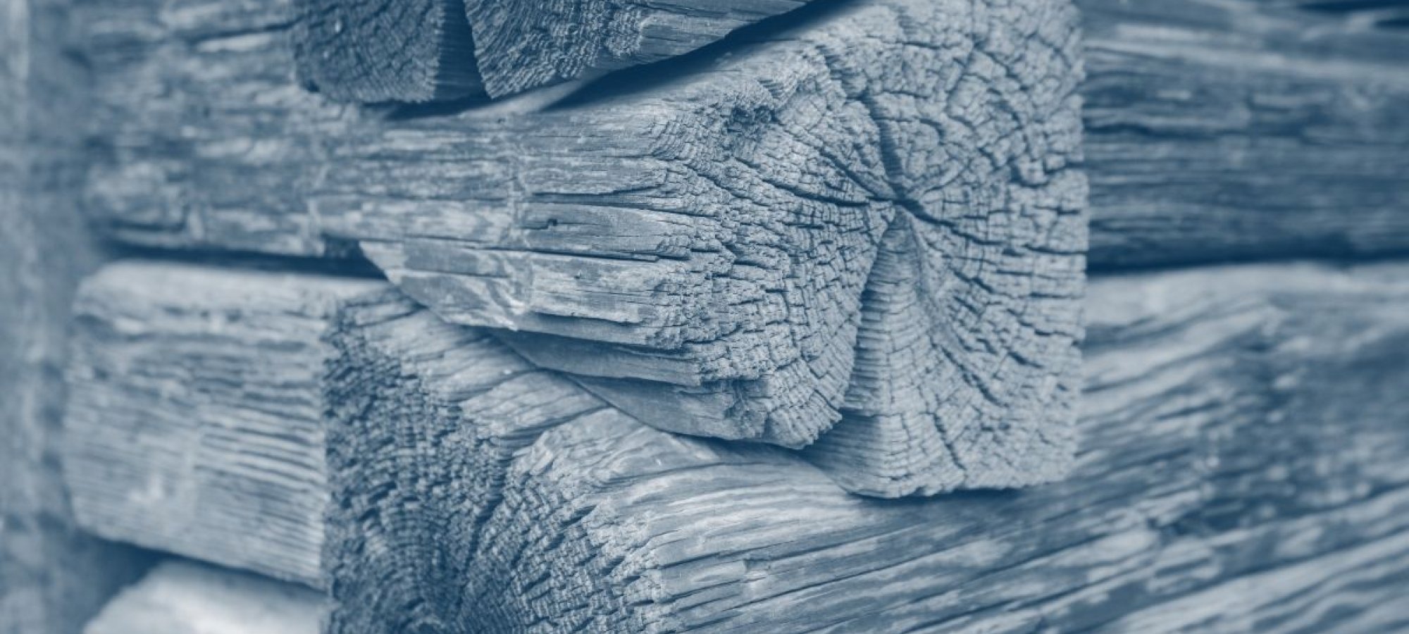 corner of a wooden cabin where the wood fits on top of each other with a blue highlight