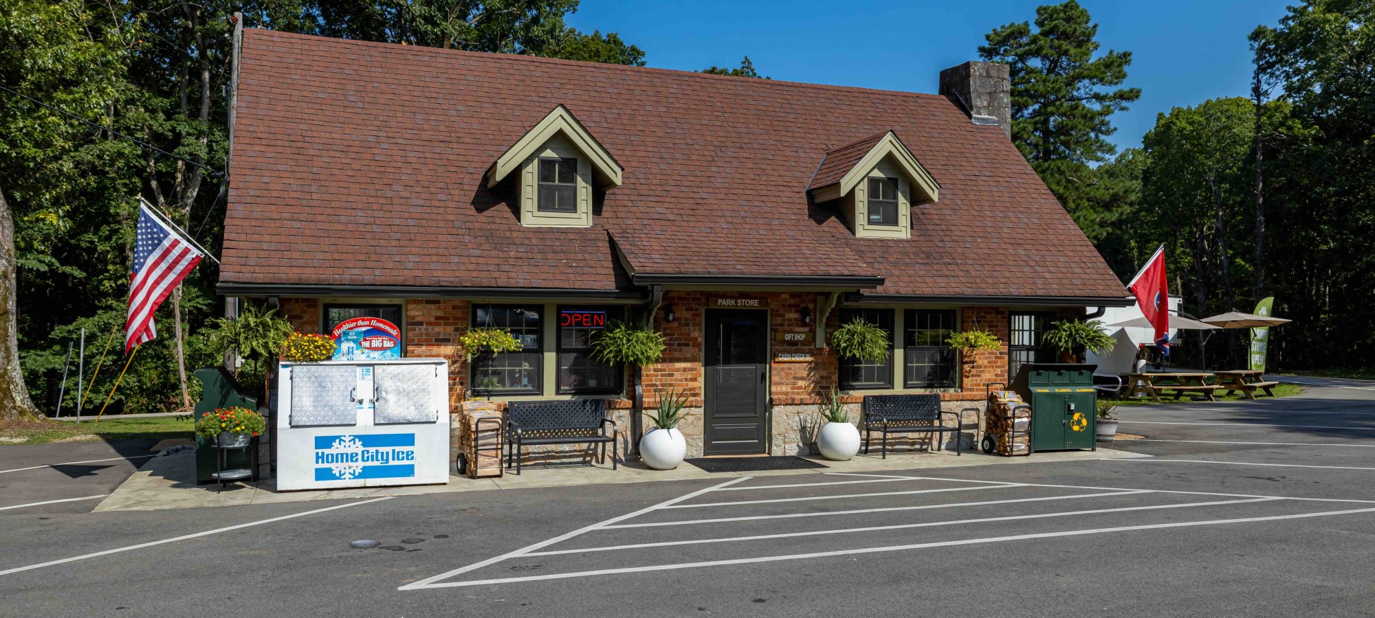 Quaint brick and wood building with American and state flags.