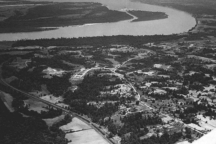 Aerial view of a winding river with surrounding landscape in grayscale.