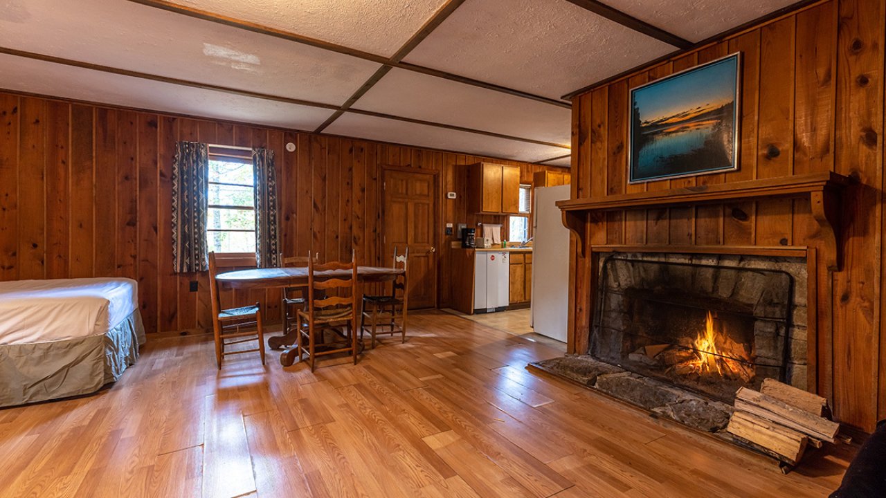 pretty fireplace inside cabin living room with dining room table and chairs 