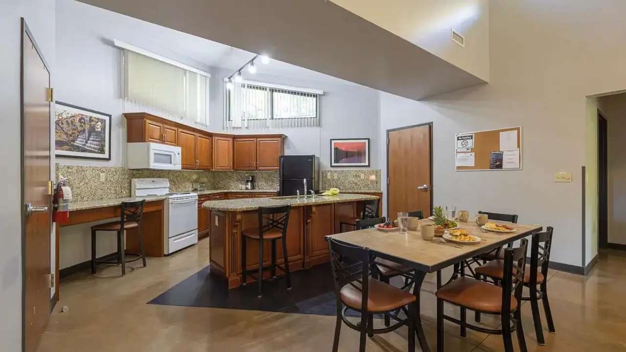 Modern kitchen and dining area with wood cabinets and granite countertops.