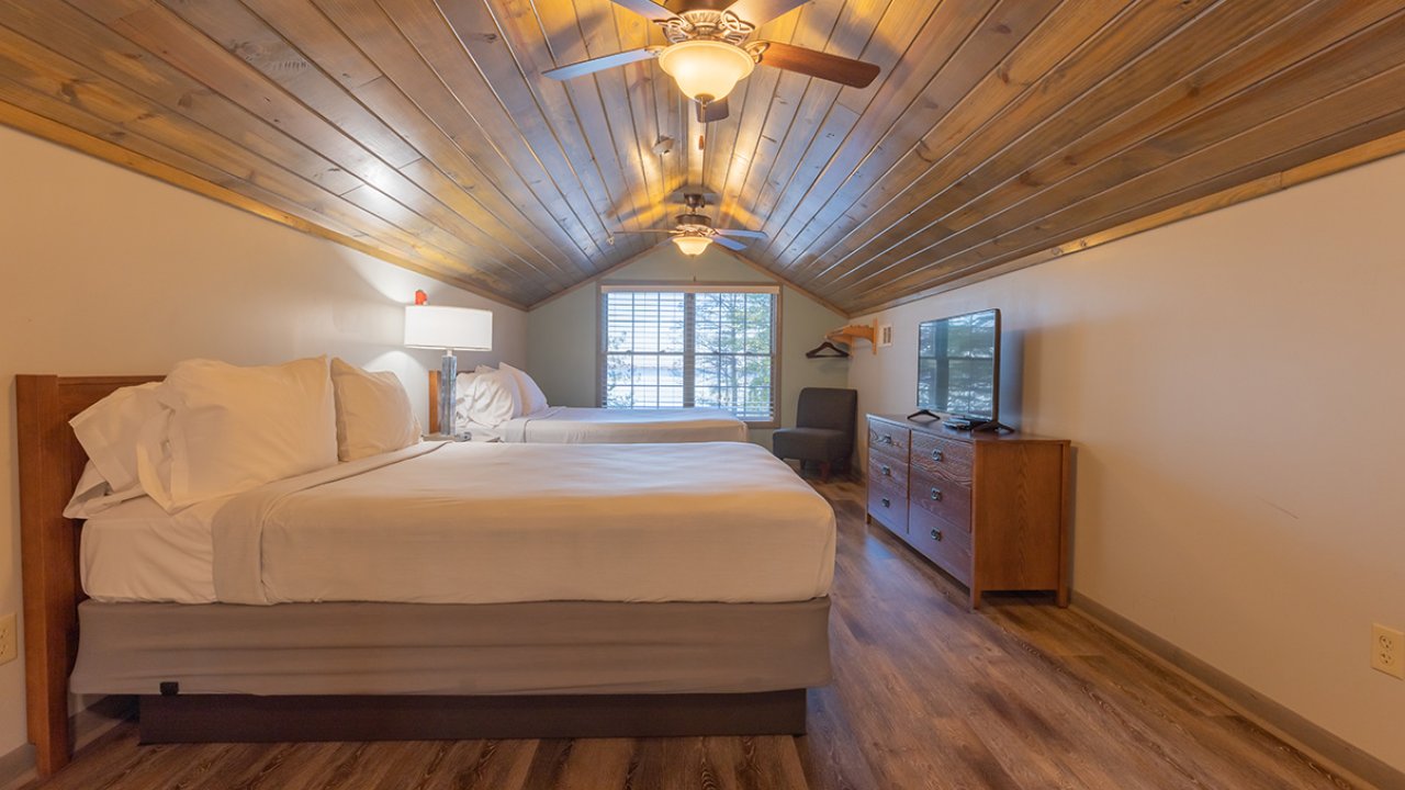 second floor bedroom with 2 beds, tv and 2 fans