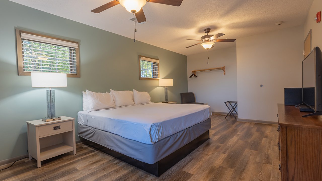 bedroom king bed with nightstands and two fans with tv stand