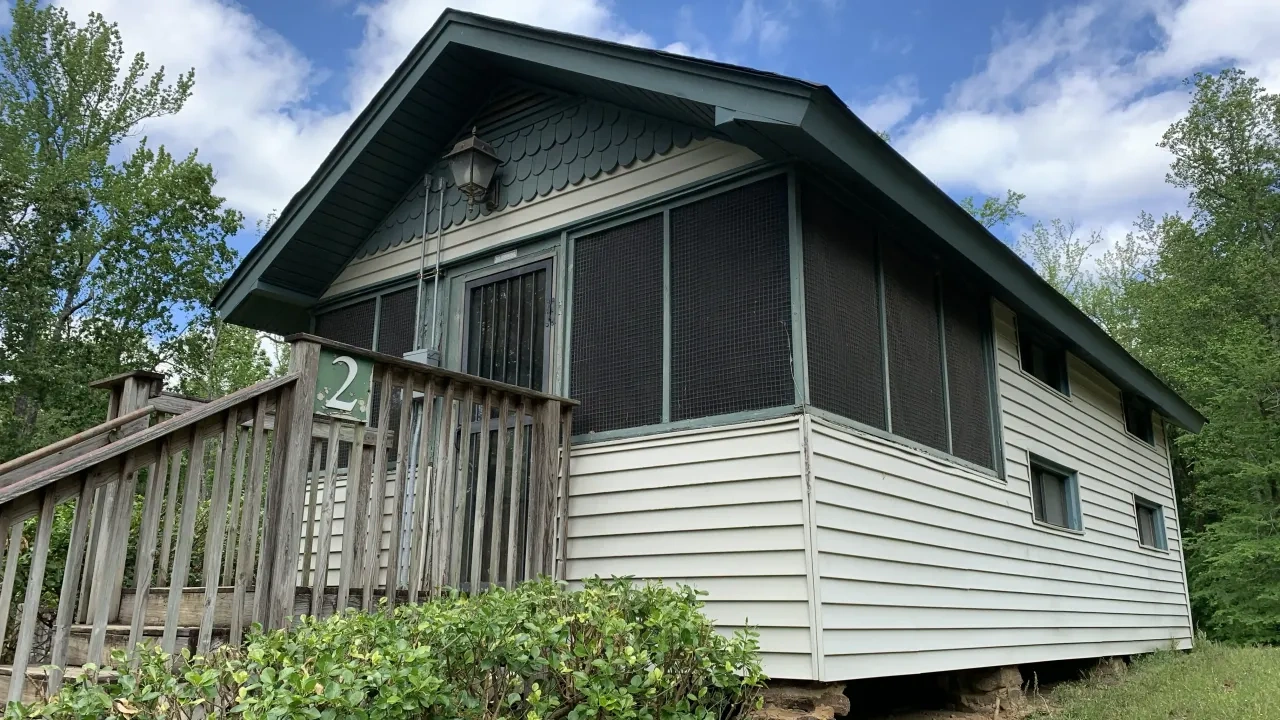 A cabin with accessible ramp sits on top of a small hill. 