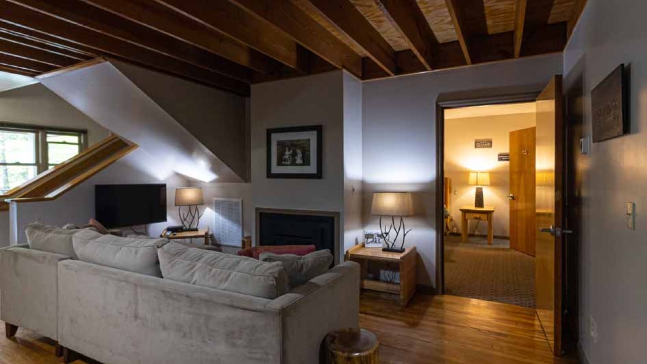 Cozy living room with exposed wooden beams and plush sofa.