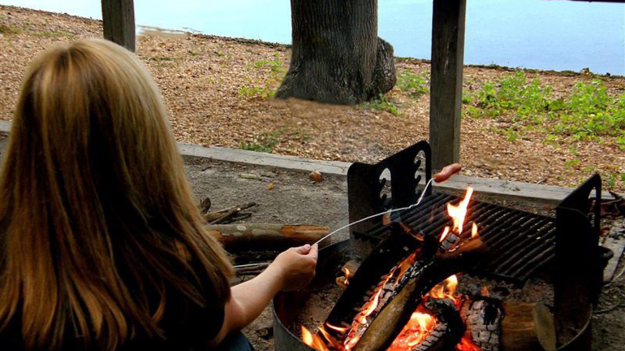 Roasting marshmallows at a campfire by the lake.