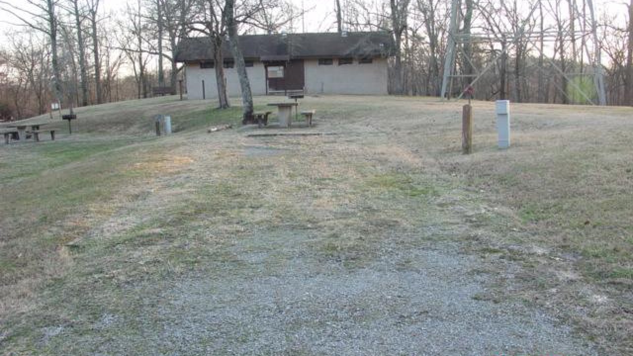 Gravel path leading to a pavilion surrounded by bare trees.