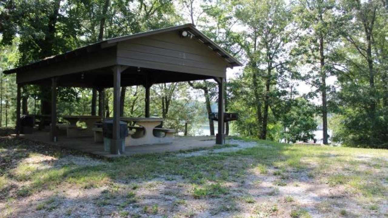 Sheltered picnic area in a leafy park setting.