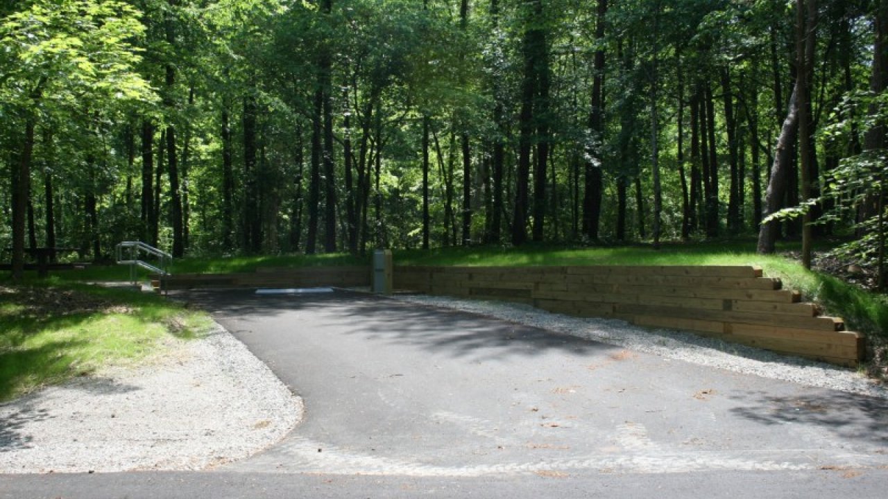 Driveway entrance surrounded by lush green trees.