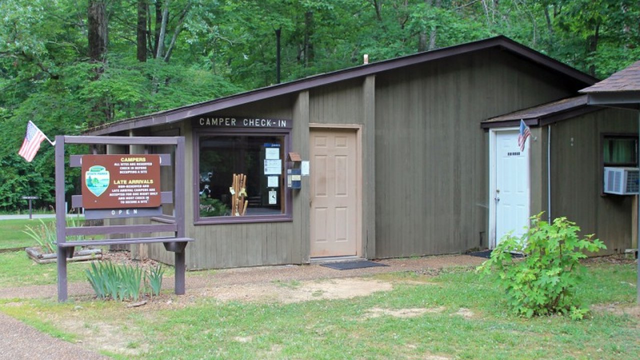 Visitor center in a park with a wooden information board.