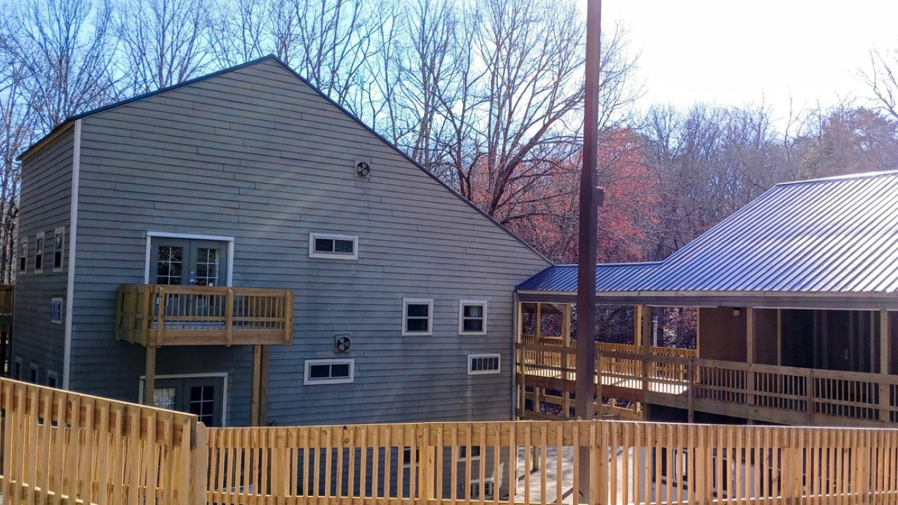 Wooden buildings with decks, surrounded by bare trees under a clear sky.