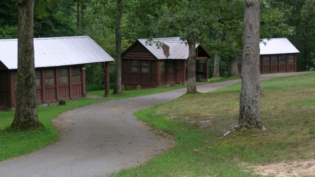 Cabins along a winding path in a wooded area.