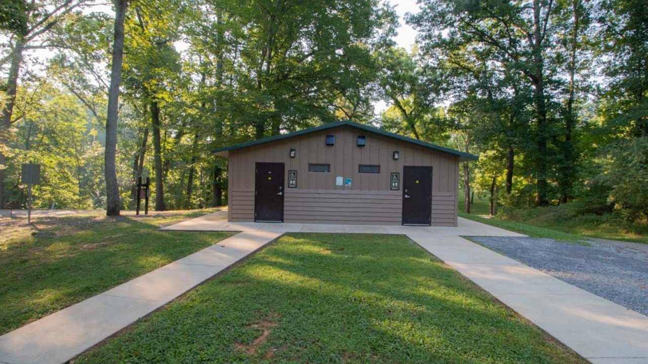 Small building in a forest clearing with two garage doors.