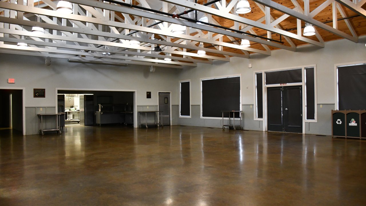 Spacious empty hall with high ceiling and polished floor.