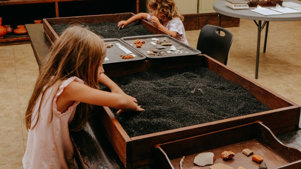 kids playing indoors with crushed rocks