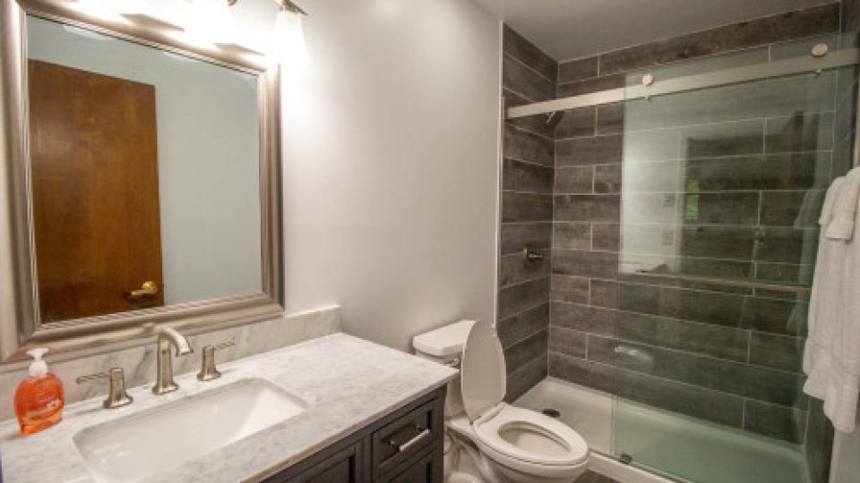 Fully furnished bathroom with modern tiles and toilet