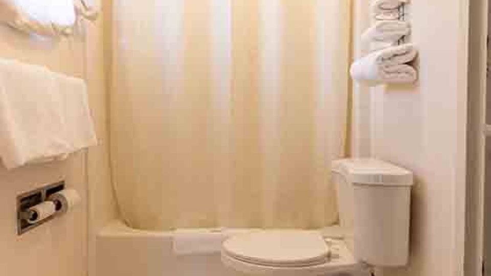tiled bathroom with white shower curtain