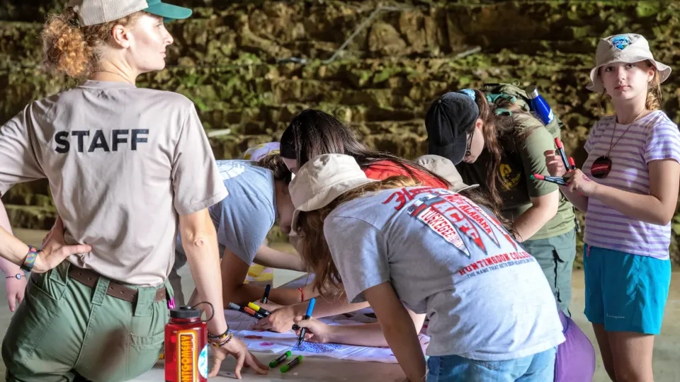 Group of people engaged in a drawing activity outdoors.