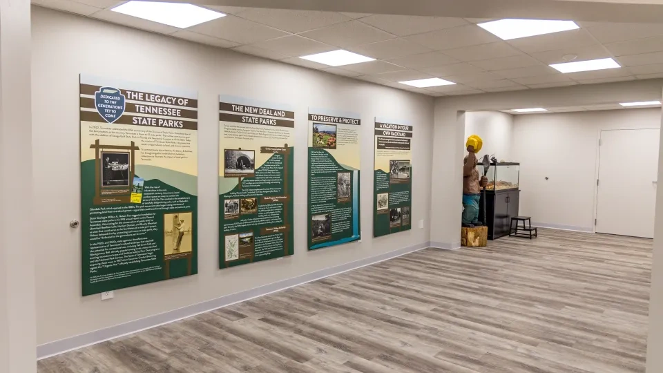 Exhibit room with park history panels and a bear sculpture.