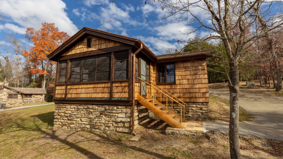 wooden shingle cabin with stair access, many windows