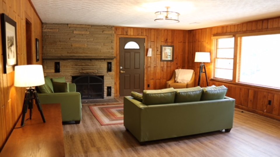 living room with two couches by entrance with wide windows and fireplace