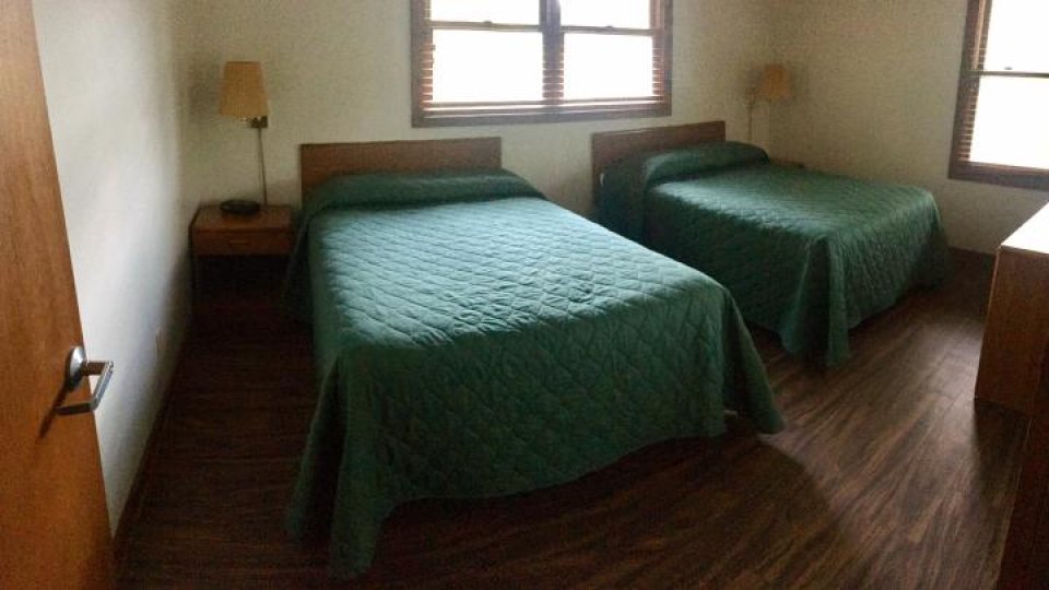 bedroom with 2 full size beds with nightstand and window