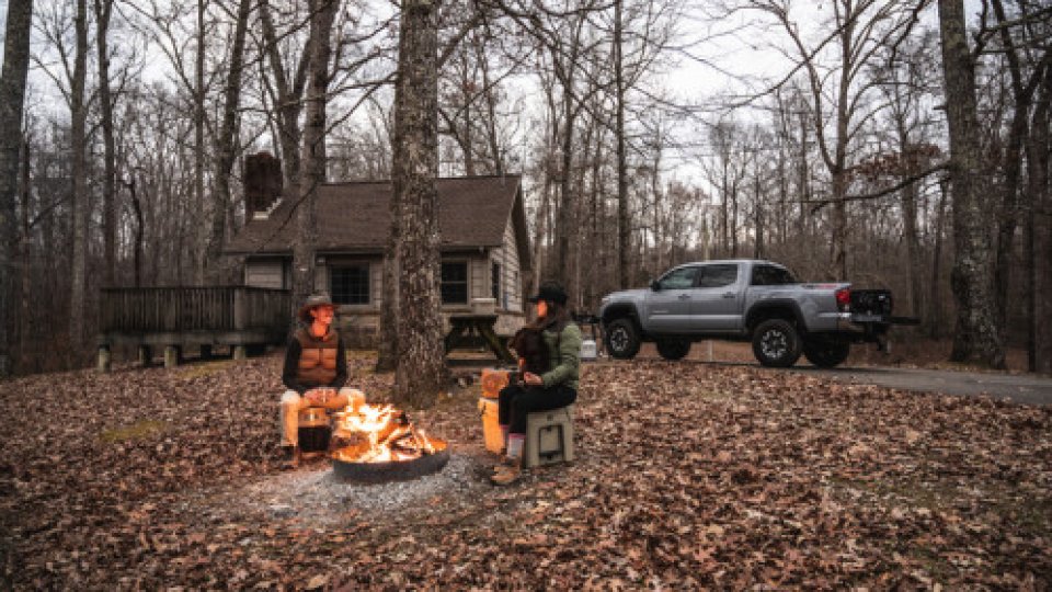 two men enjoying a campfire in the fall