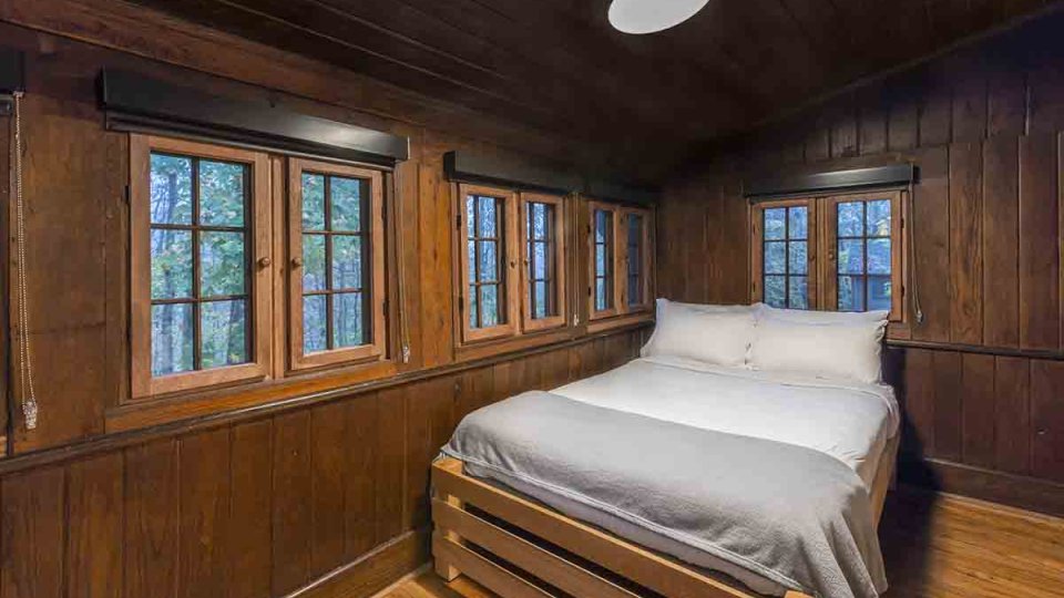 rustic cabin, single bed with hardwood flooring