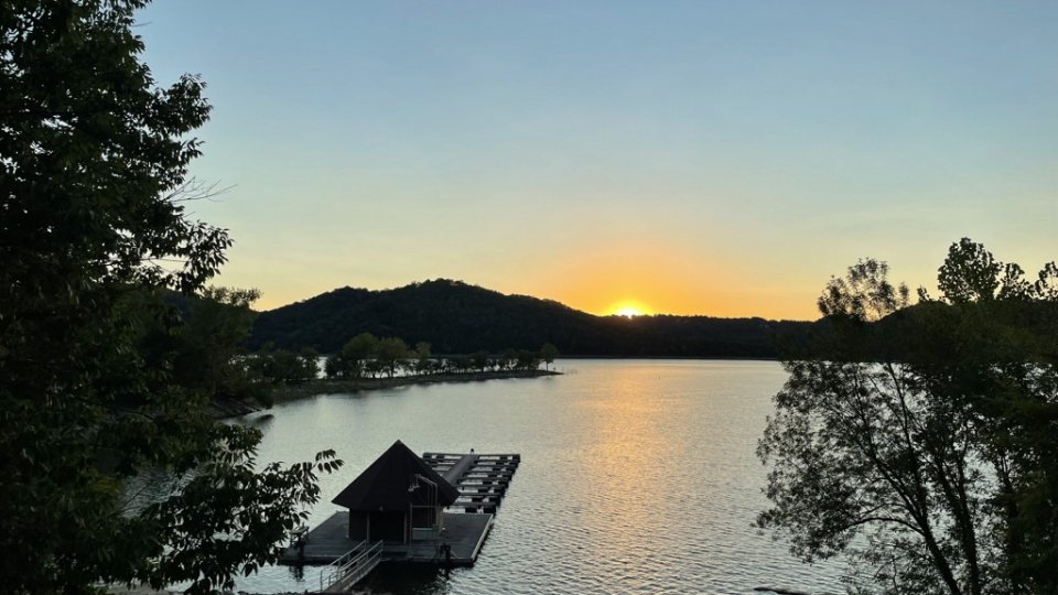 landscape view of the lake and the dock on the shore at sunset